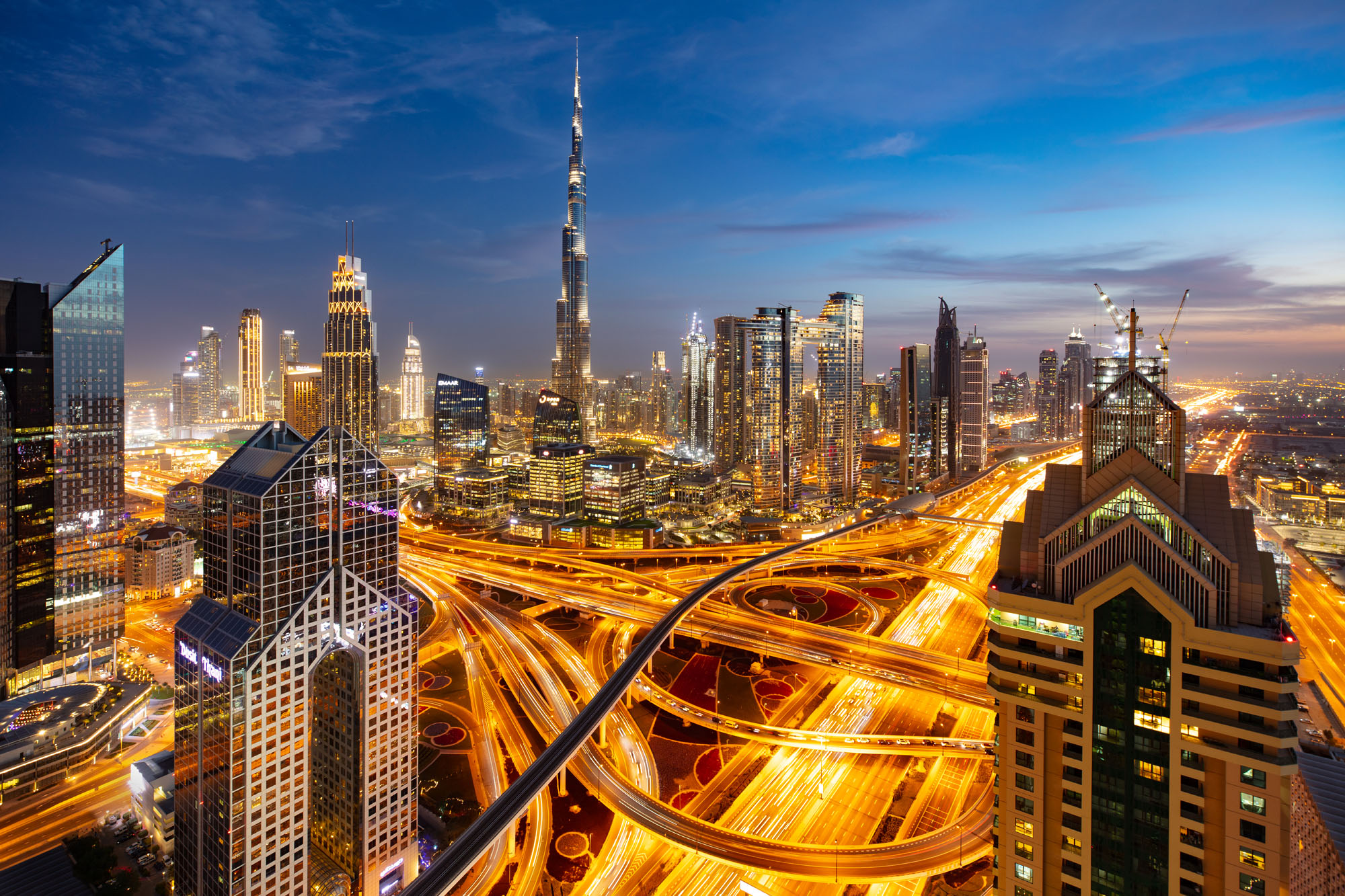 La skyline de Dubaï à l'heure bleue vue depuis l'hôtel shangri-la. Burj Khalifa au loin et filés de voitures au premier plan.