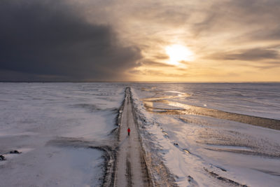 Une route qui s'arrête au milieu de nulle-part et un personnage face au sunset.