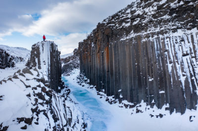 Studlagil canyon en hiver avec ses orgues basaltiques et la rivière gelée.