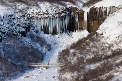 Svartifoss en hiver et son pont de bois.