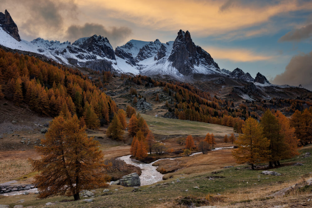 La haute vallée de la Clarée en automne, au sunset, avec de la neige sur les montagnes et les mélèzes rouges.