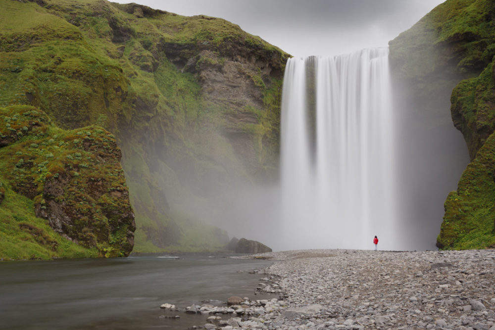 Personnage devant Skogafoss en Islande. Pose longue et filé d'eau.
