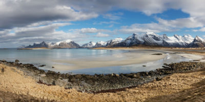 La plage de Fredvang et les montagnes enneigées dans les îles Lofoten en Norvège.