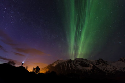 Personnage et aurore boréale au-dessus du Volandstind dans les îles Lofoten en Norvège.