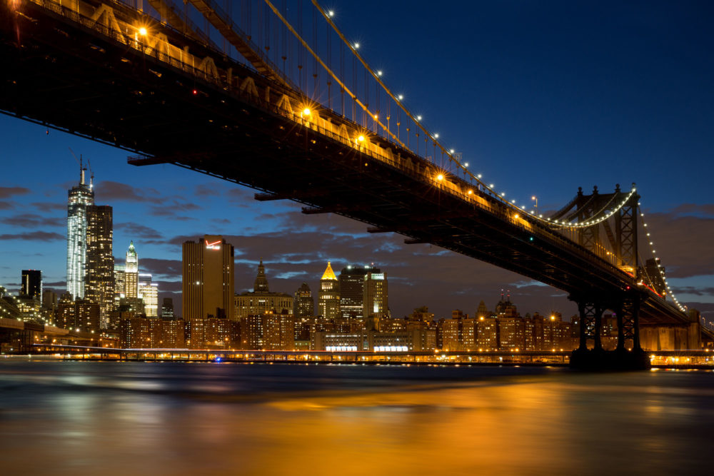 Manhattan bridge de nuit vu de Brooklyn avec une pose longue sur l'East River.