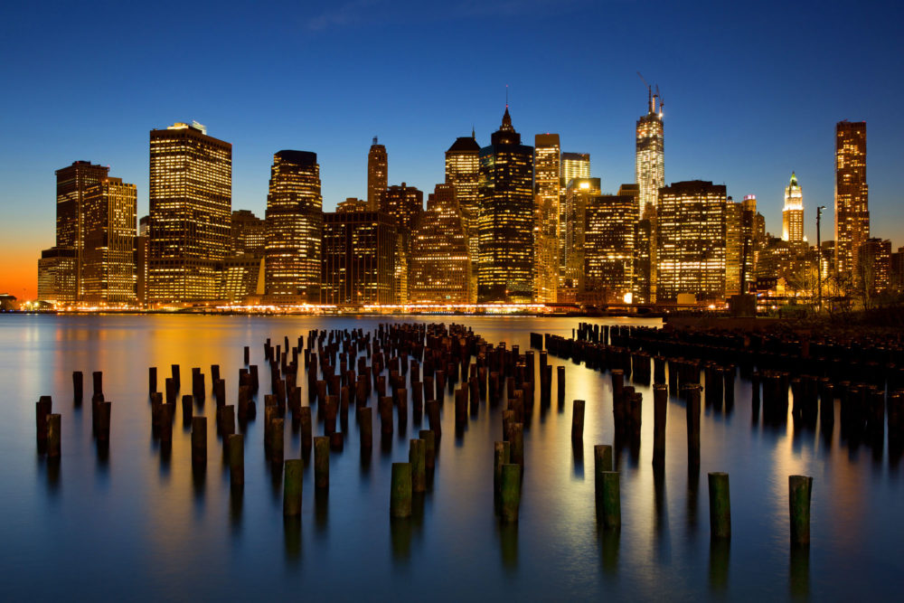 Manhattan à l'heure bleue vu de Brooklyn avec une pose longue sur l'east river.