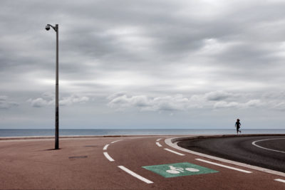 Personnage sur une piste cyclable en bord de mer.