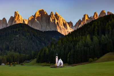 La chapelle de St-Johann le soir avec les montagnes dans le soleil couchant.