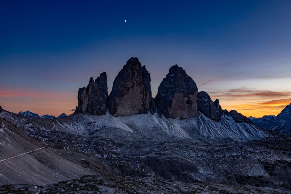 Les tre cime di lavaredo au sunset avec la lune dans le ciel et les couleurs du sunset.